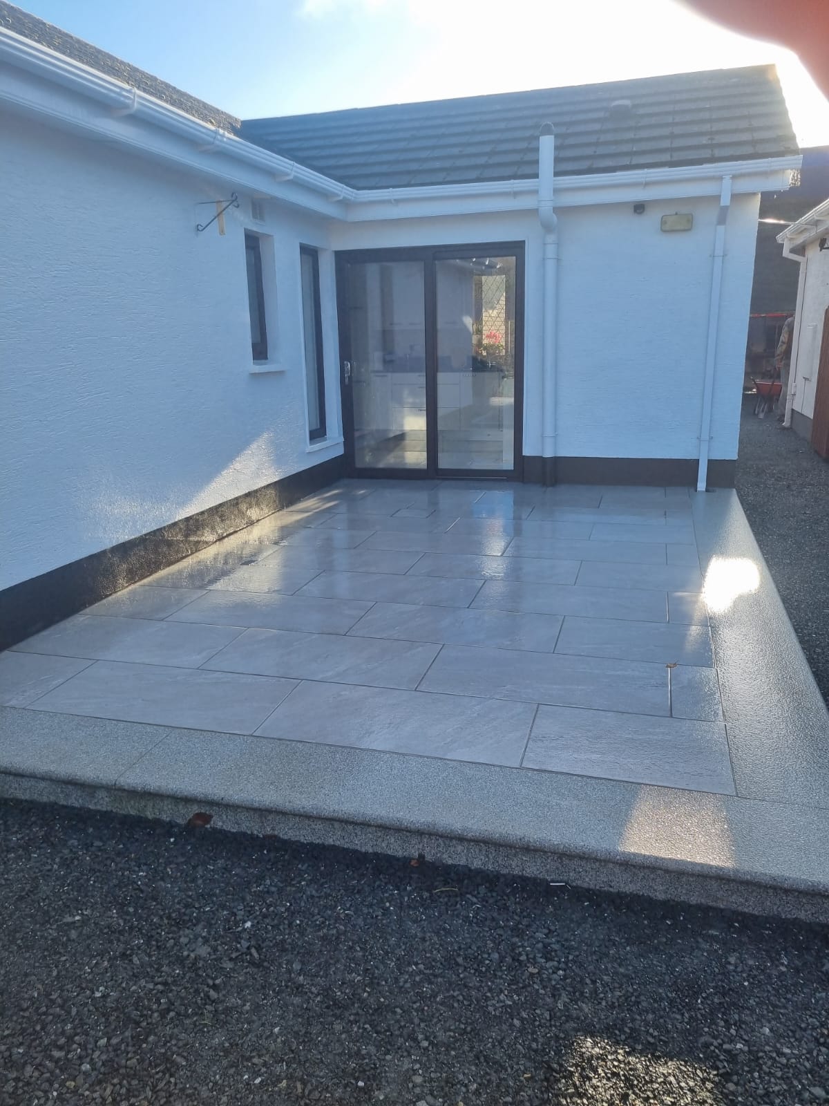 Light-grey porcelain patio with an exposed-aggregate border at a Dublin home, laid by Delaney Tarmac