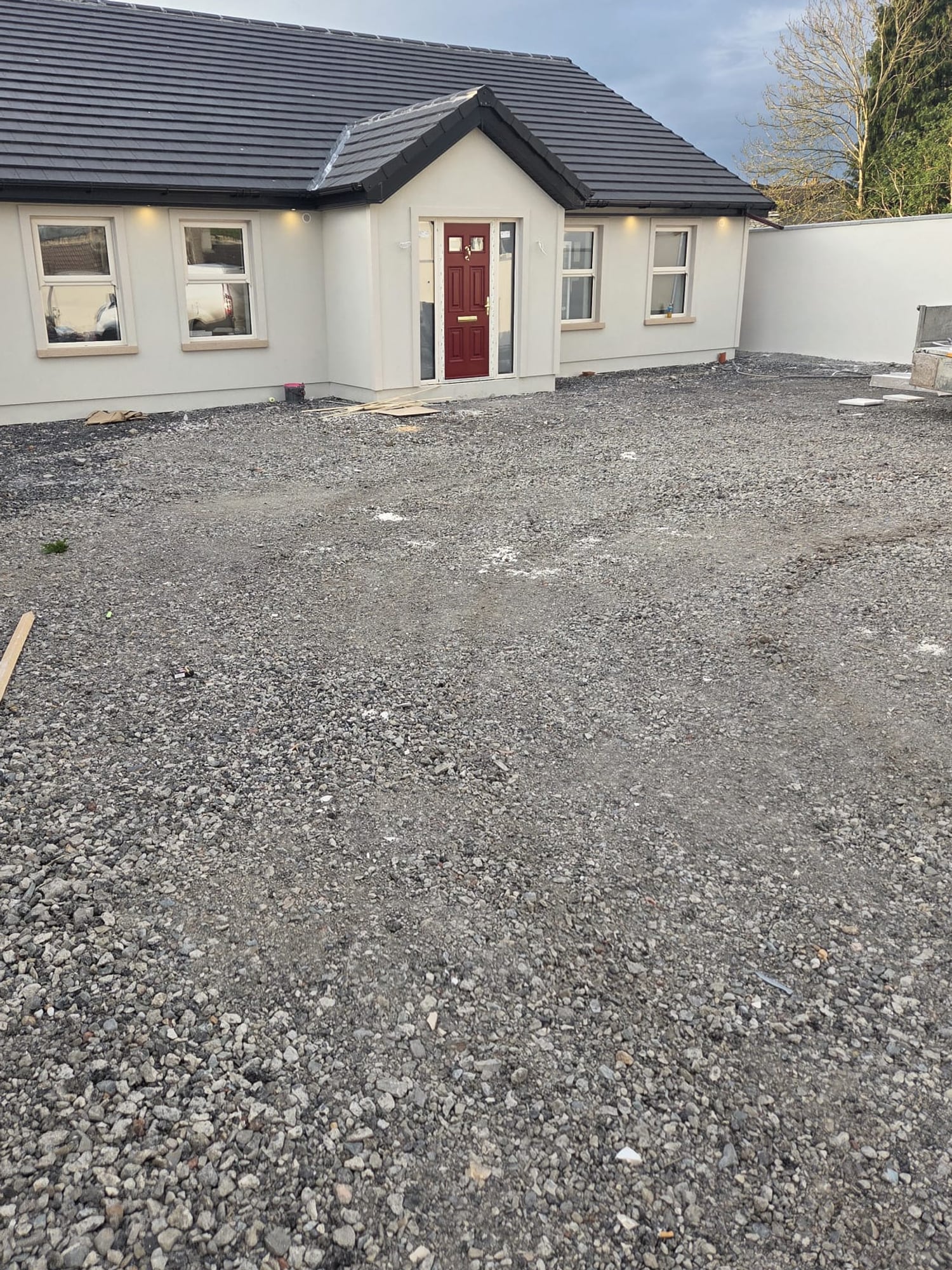 Loose stone across the front of a new bungalow before the tarmac driveway and paved apron were laid