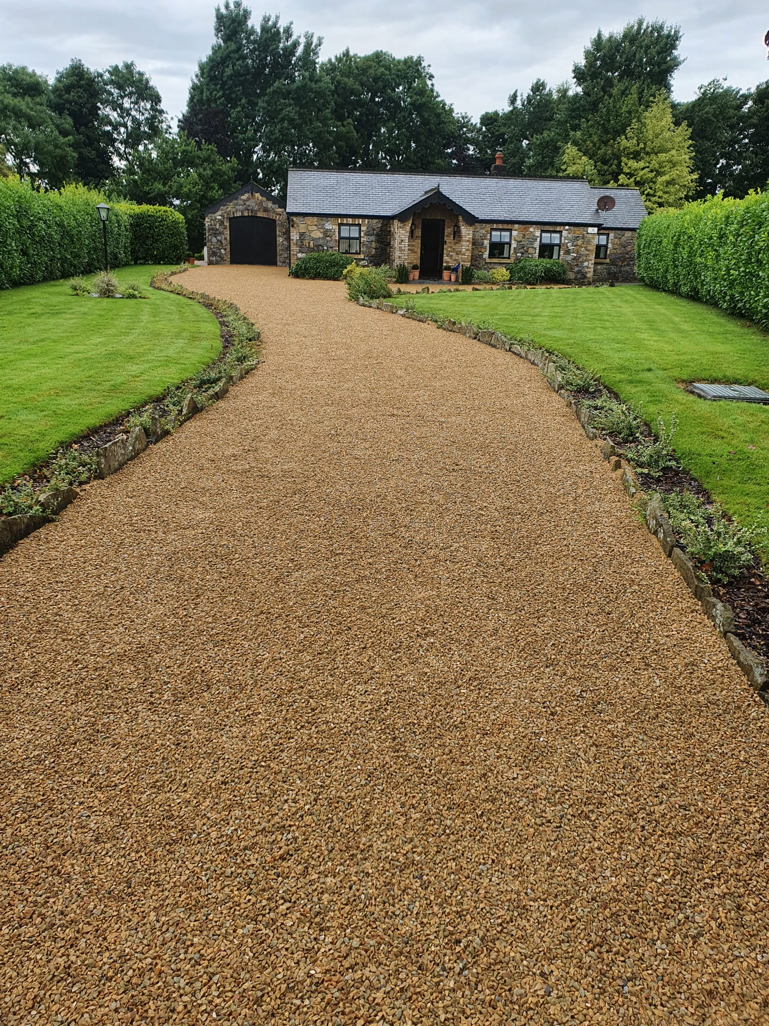 Golden gravel driveway leading to a traditional Irish stone cottage