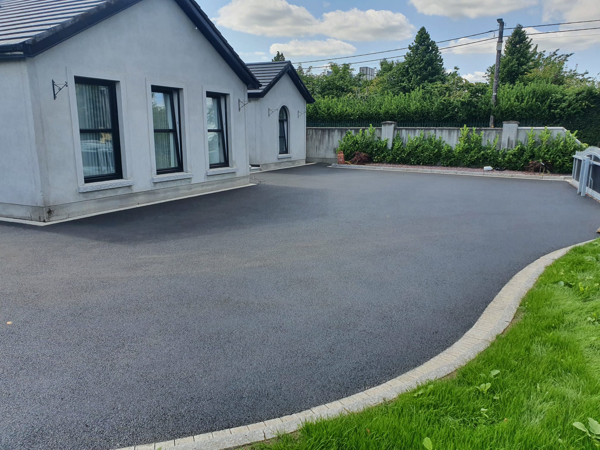 Curving tarmacadam driveway with a granite border at a Dublin bungalow, a recent Delaney Tarmac install