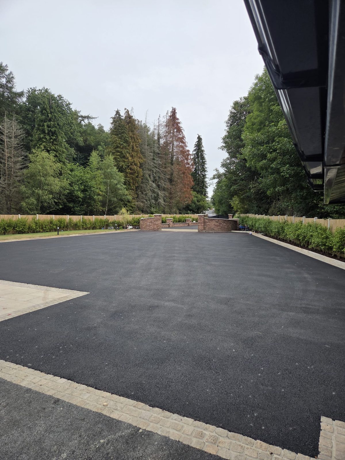 Large machine-laid tarmac forecourt with brick pillars at a country property, laid by Delaney Tarmac