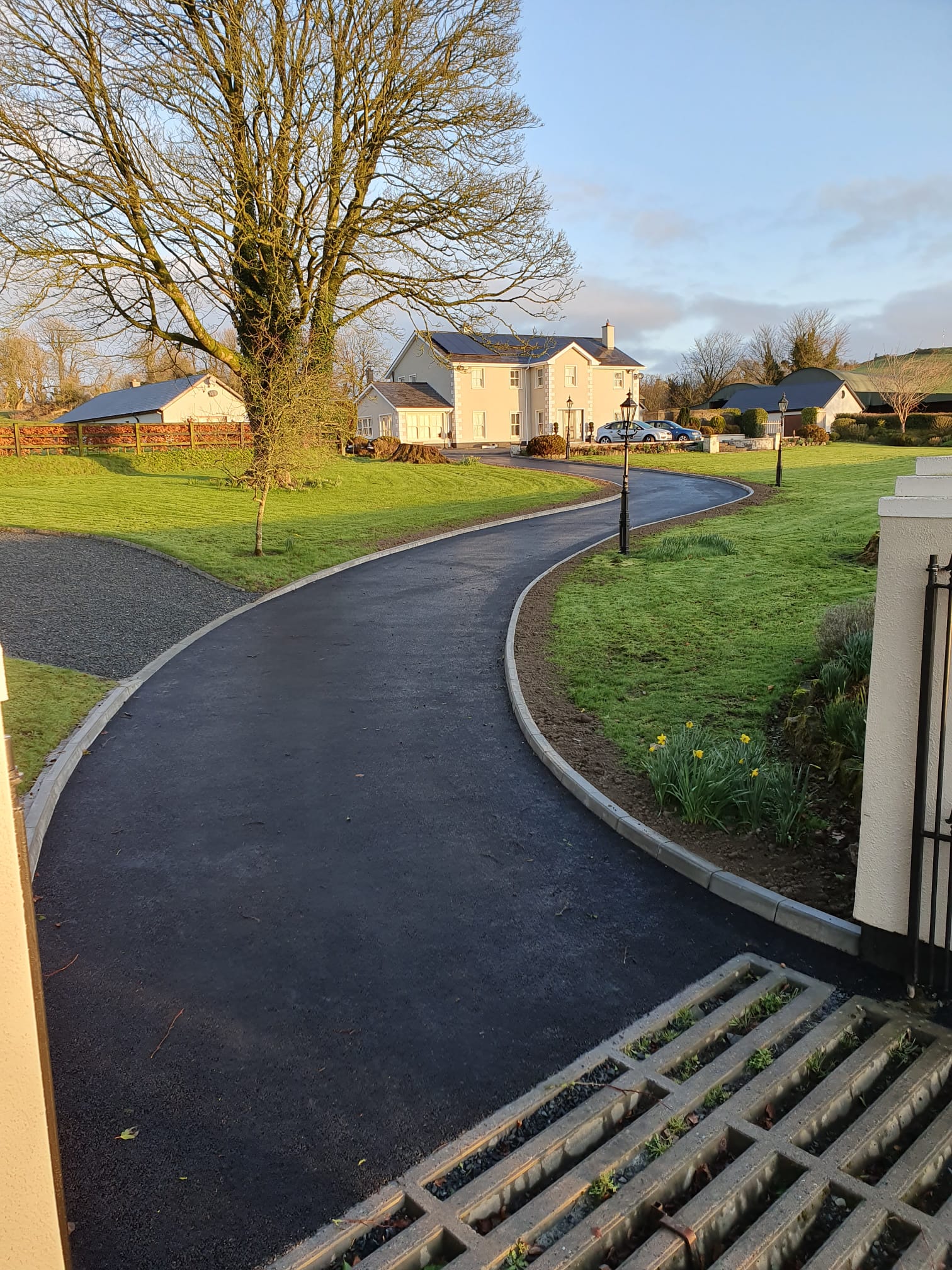 Sweeping tarmac driveway leading to a detached country house