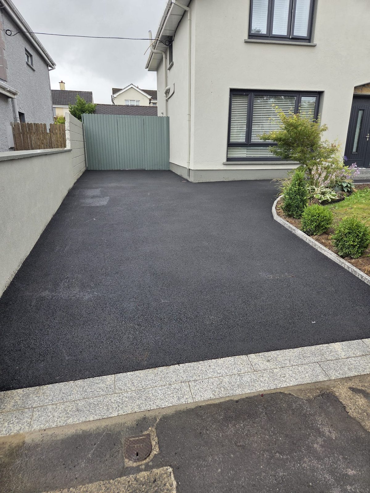 Machine-laid tarmacadam driveway with a silver granite border and apron at a suburban home, laid by Delaney Tarmac