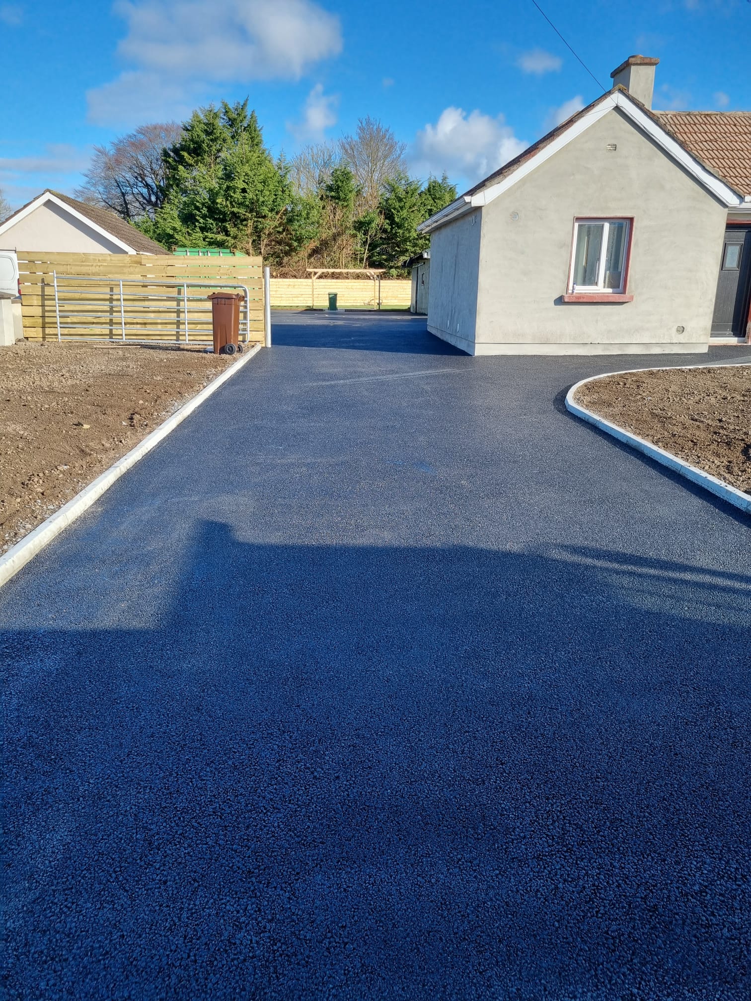 Tarmac driveway at a bungalow with a grey cobblelock edge band