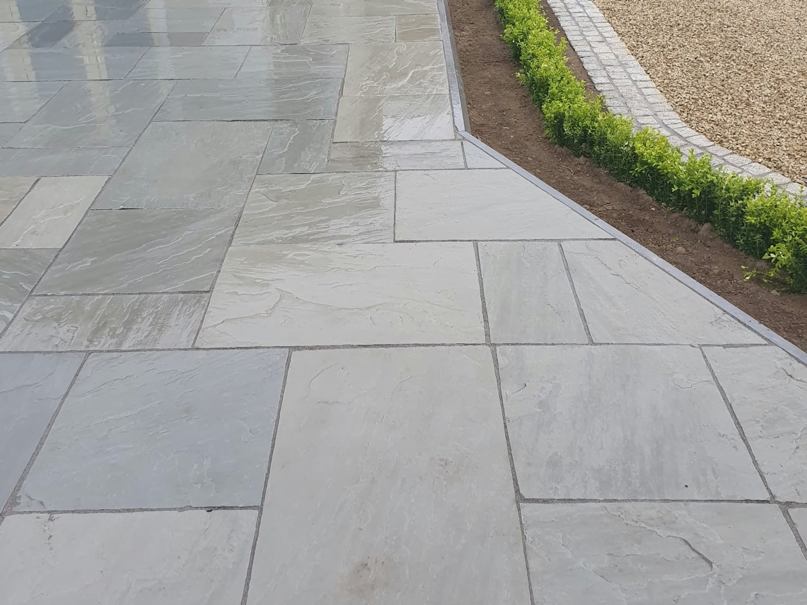 Riven flag paving path beside a gravel drive