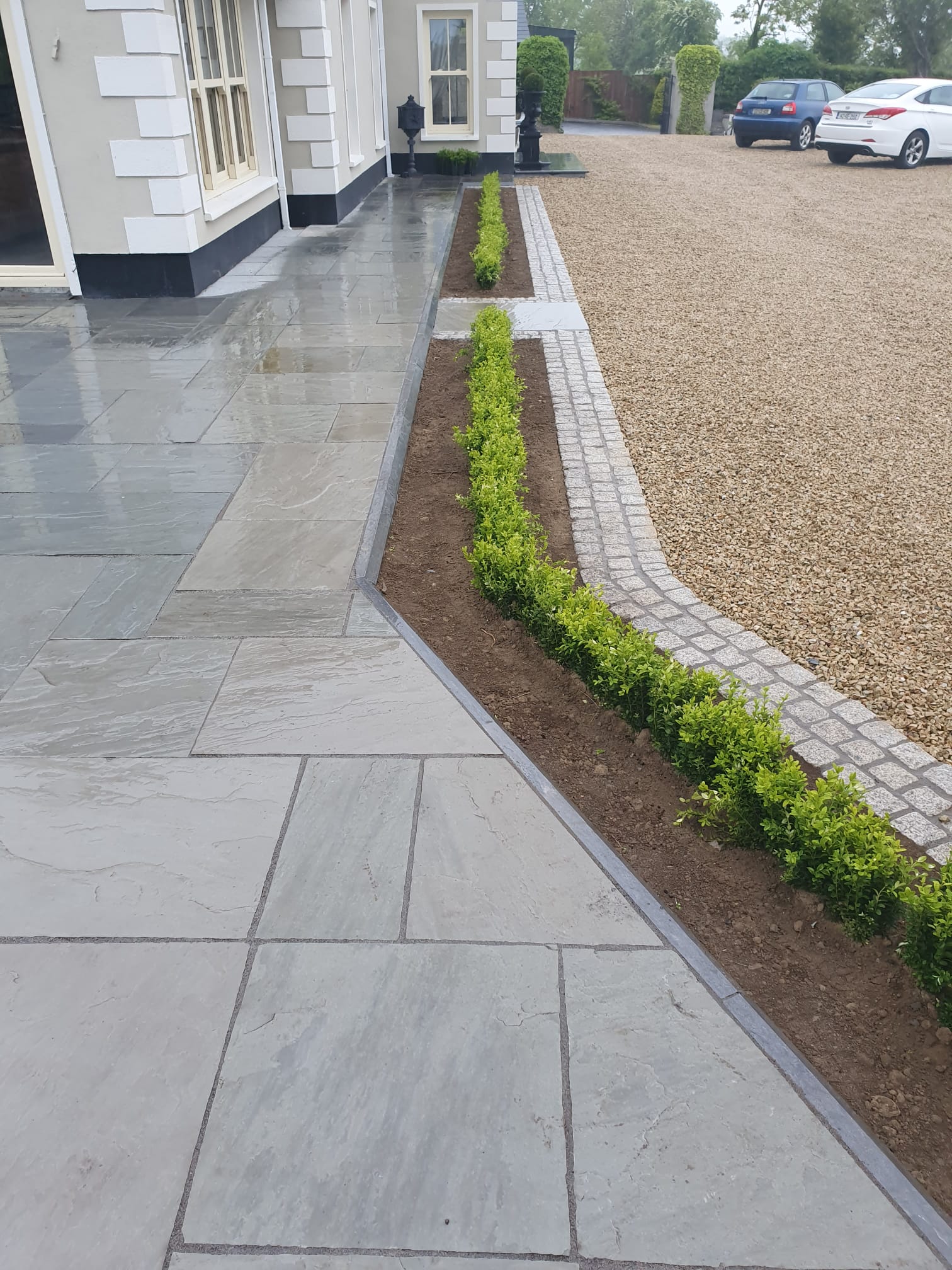 Natural granite slab front entrance patio with cobble border and gravel feature