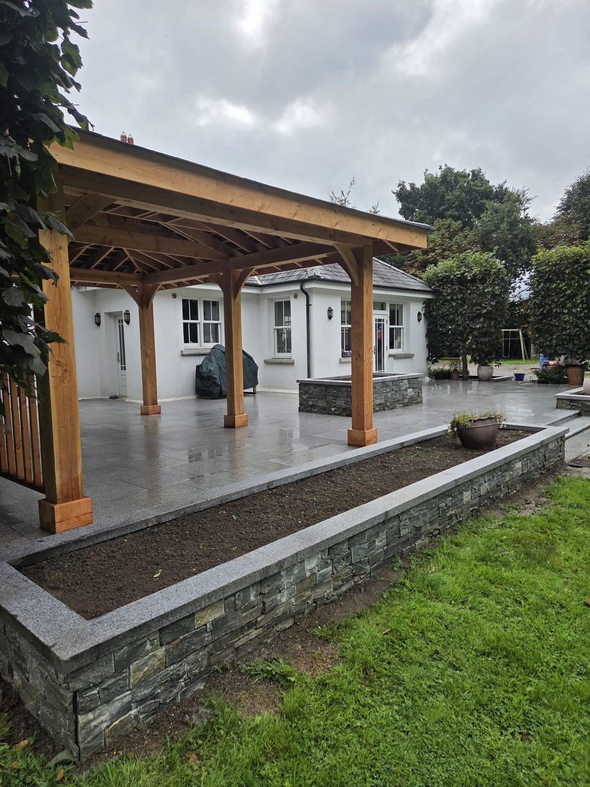 View out from under the cedar gazebo across the granite patio to the lawn