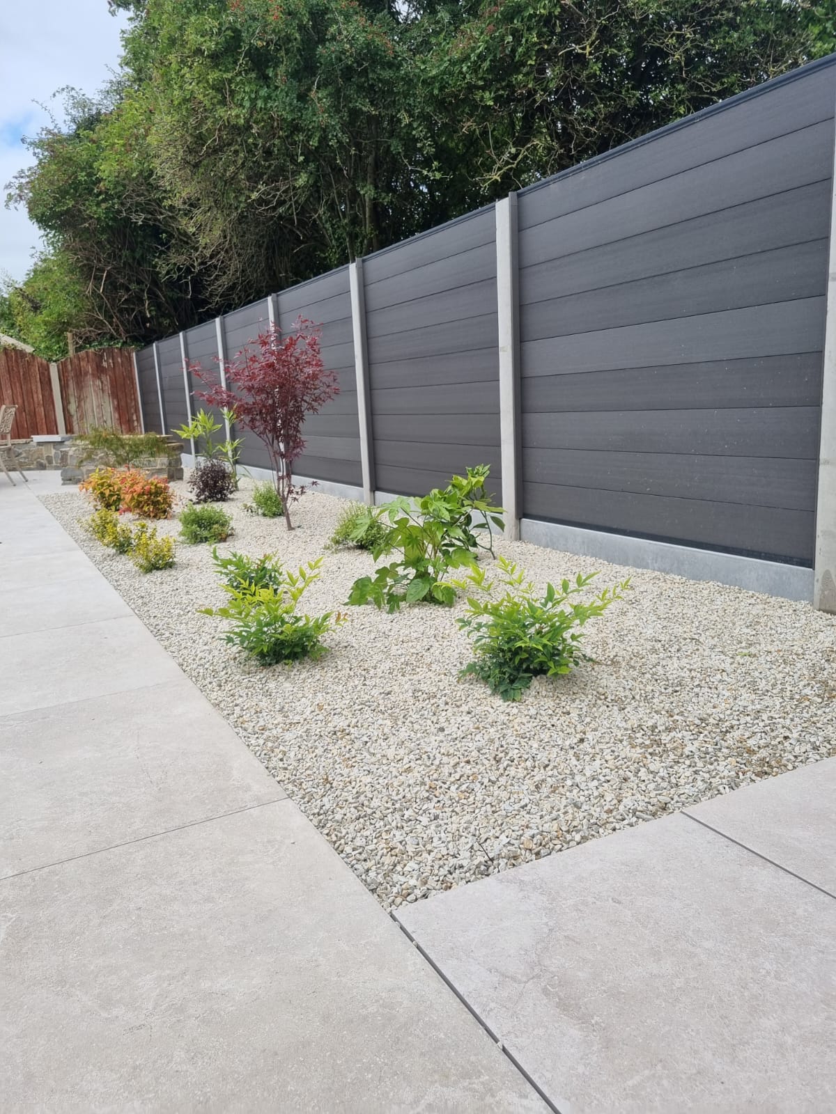 Natural stone patio with fencing and planting