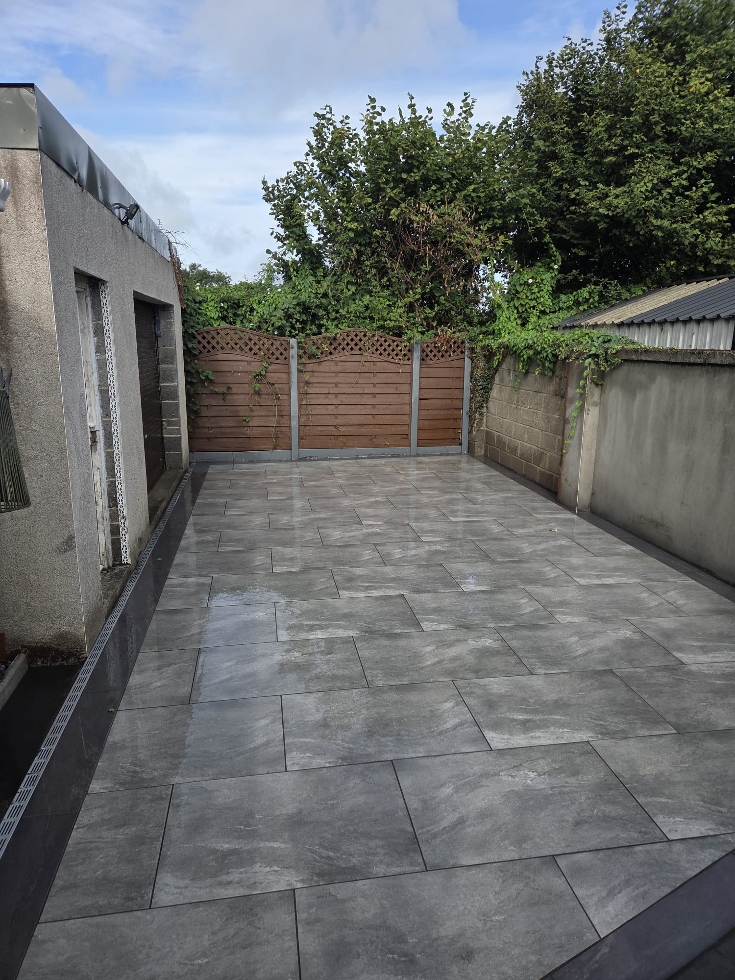 Grey marble-effect porcelain patio in an enclosed side yard