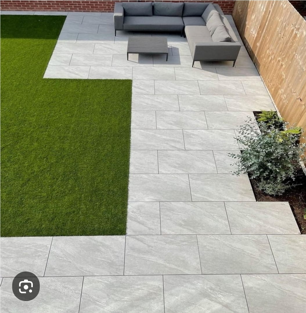 Grey porcelain patio with lounge area and artificial lawn