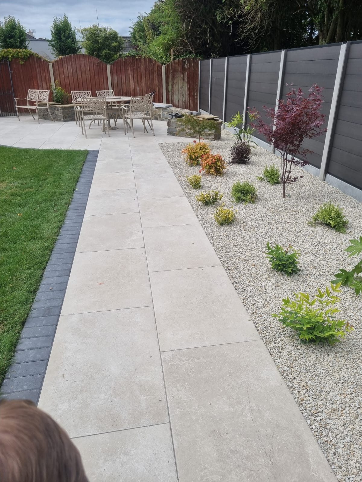 Porcelain patio walkway with gravel border and planting