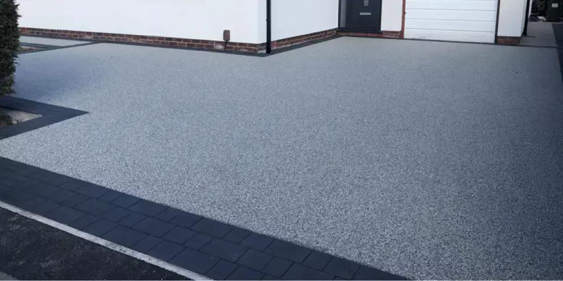 Light grey resin bound driveway with charcoal block border