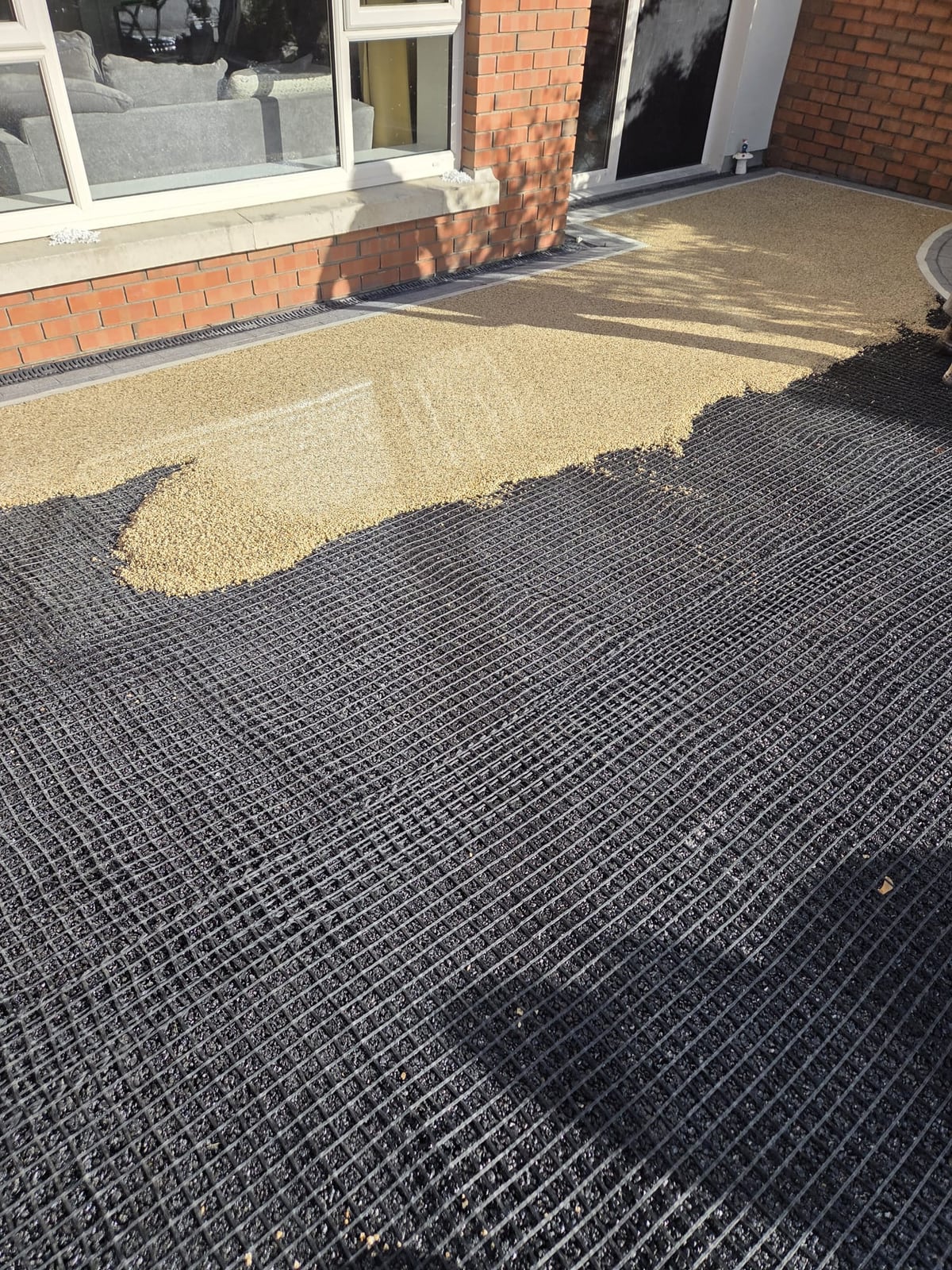 A grid over the black base with the resin-bound stone going down from the house outwards