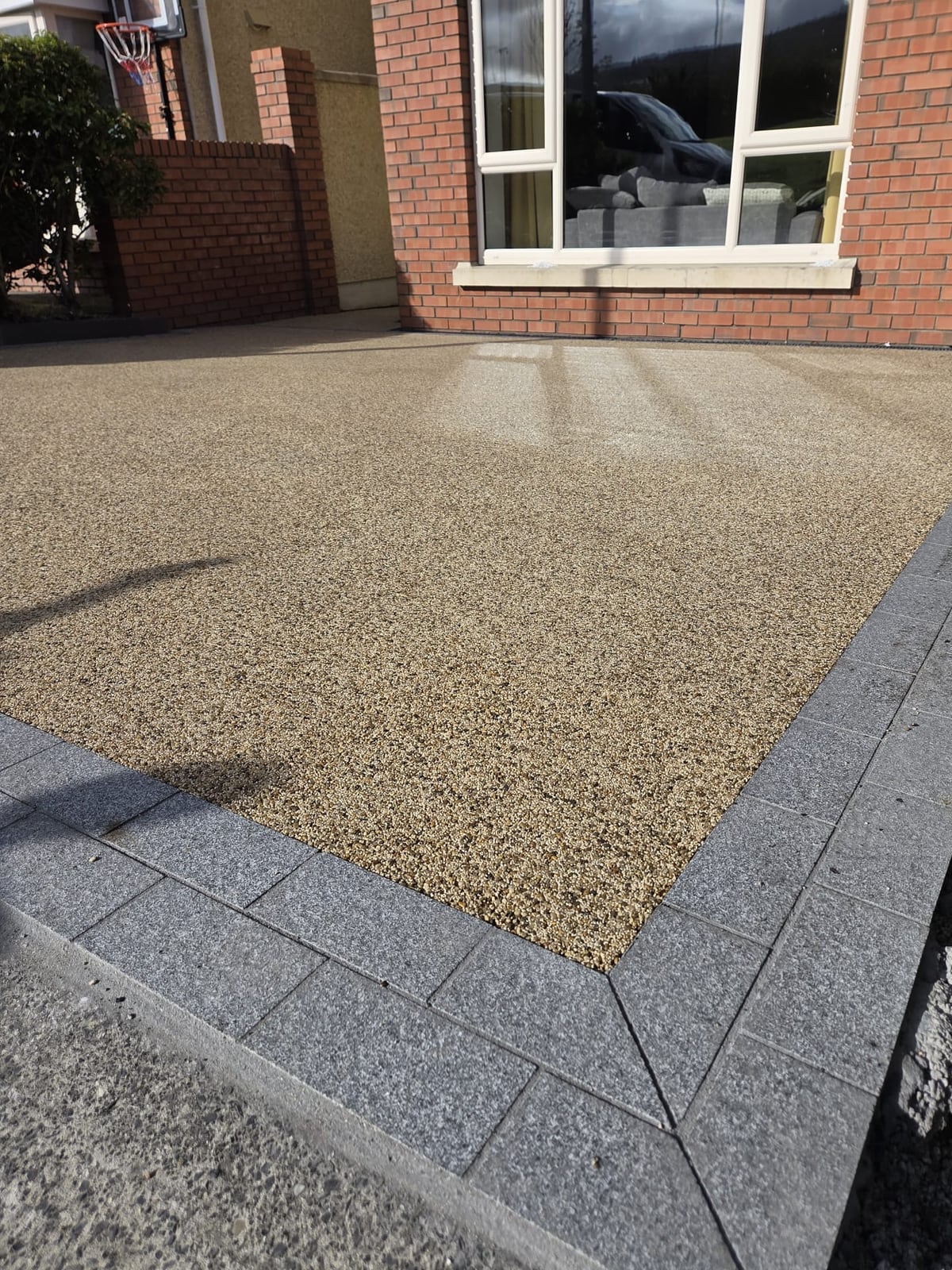 The mitred corner of the double granite border against the finished resin-bound surface